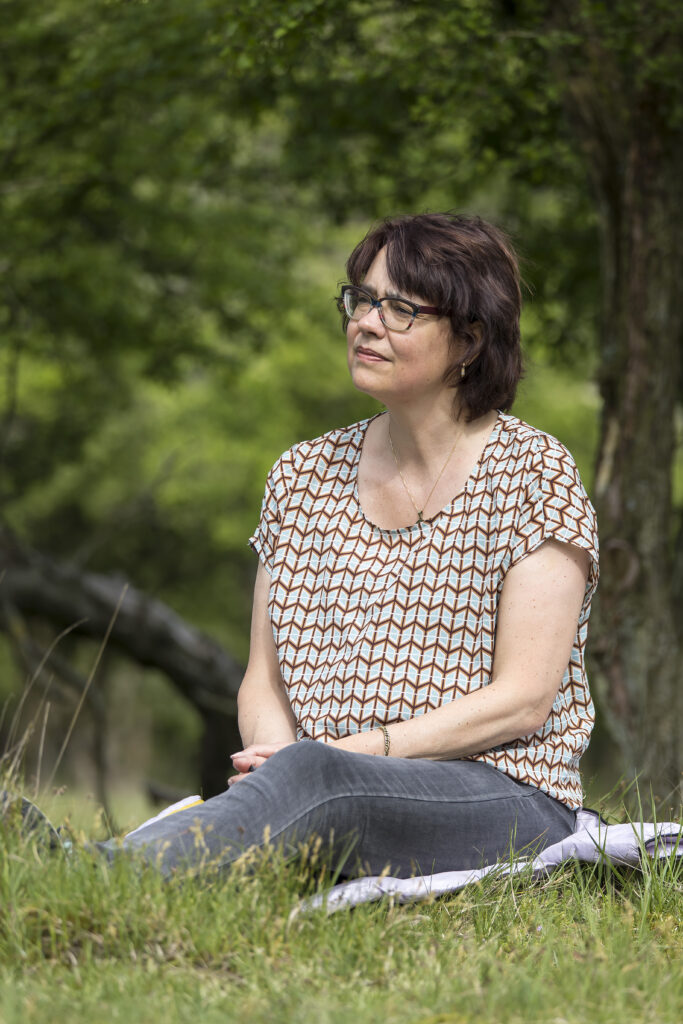 focusing, vrouw zittend op haar jas in het gras