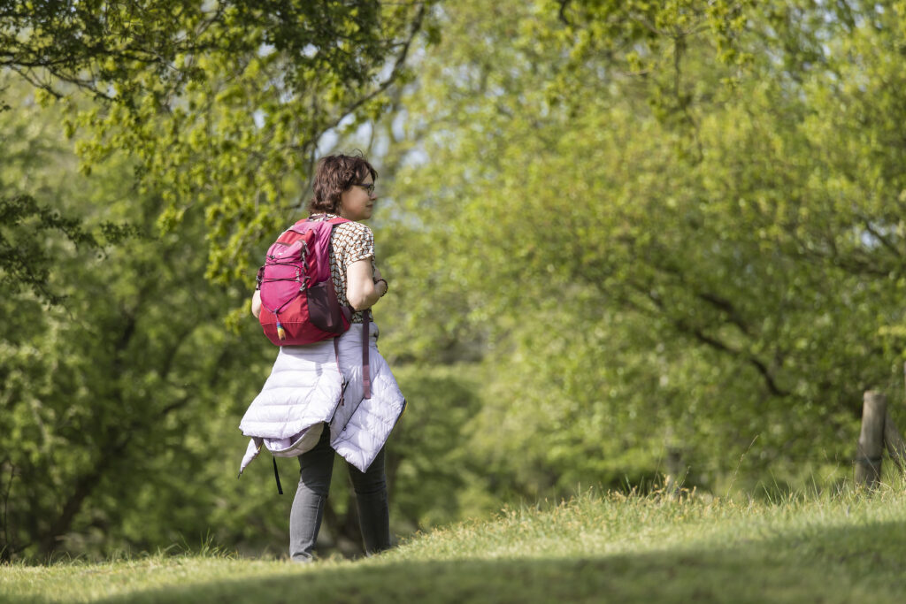 vrouw met rugzak in het bos, altijd maar doorgaan